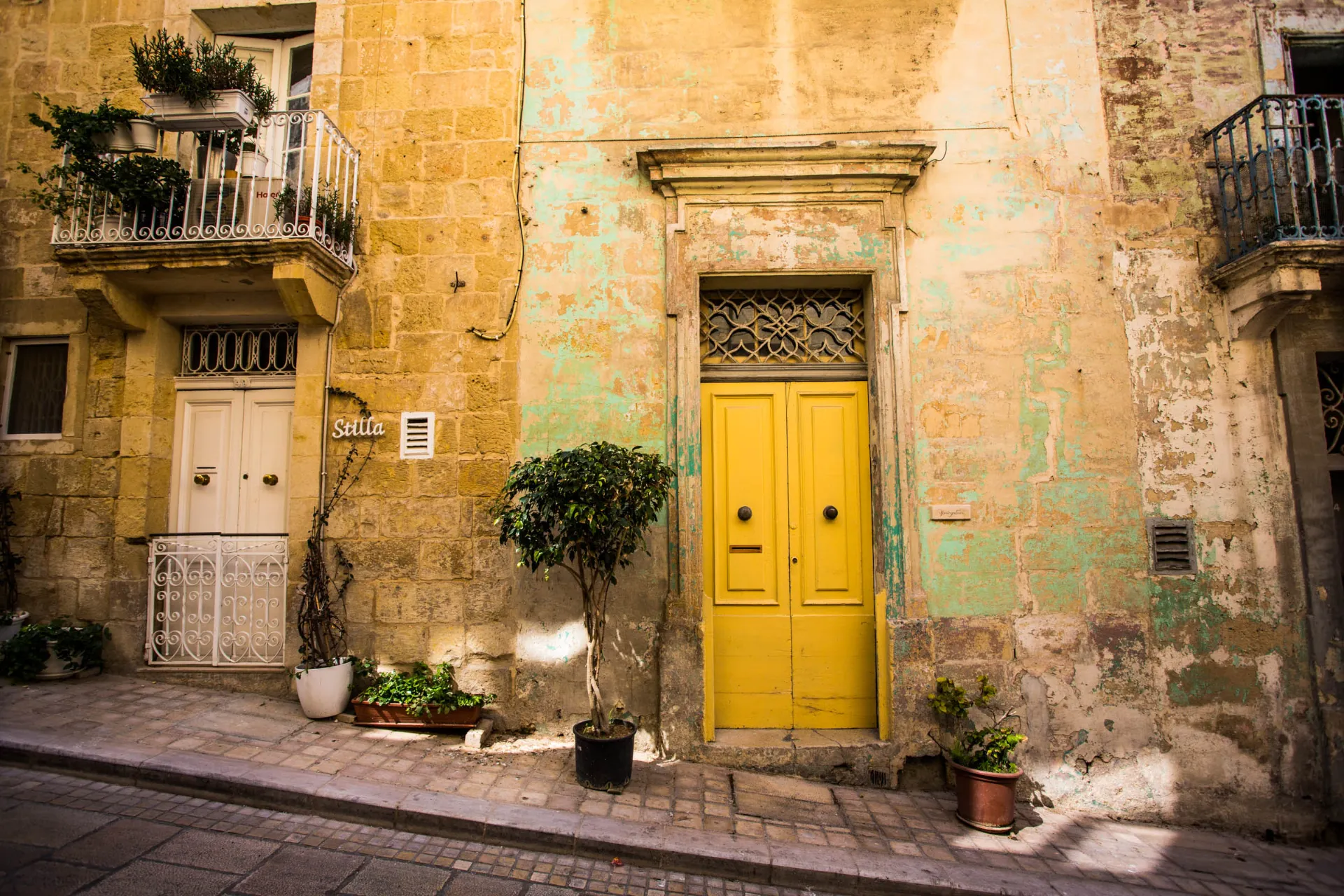 Sjarmerende fasade med gul dør i Vittoriosa – et eksempel på Maltas fargerike bymiljø