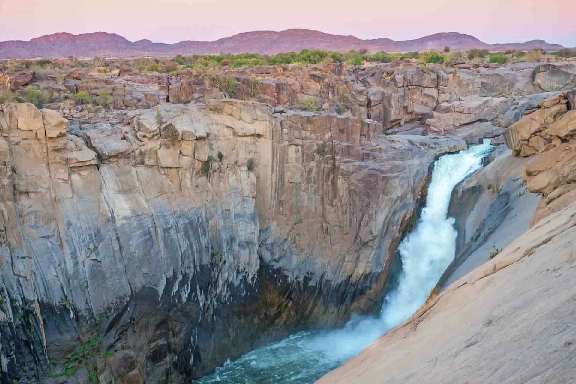 Augrabiesfallene dannes av Oransjeelven og er ca. 56 m høye Augrabiesfallene dannes av Oransjeelven og er ca. 56 m høye