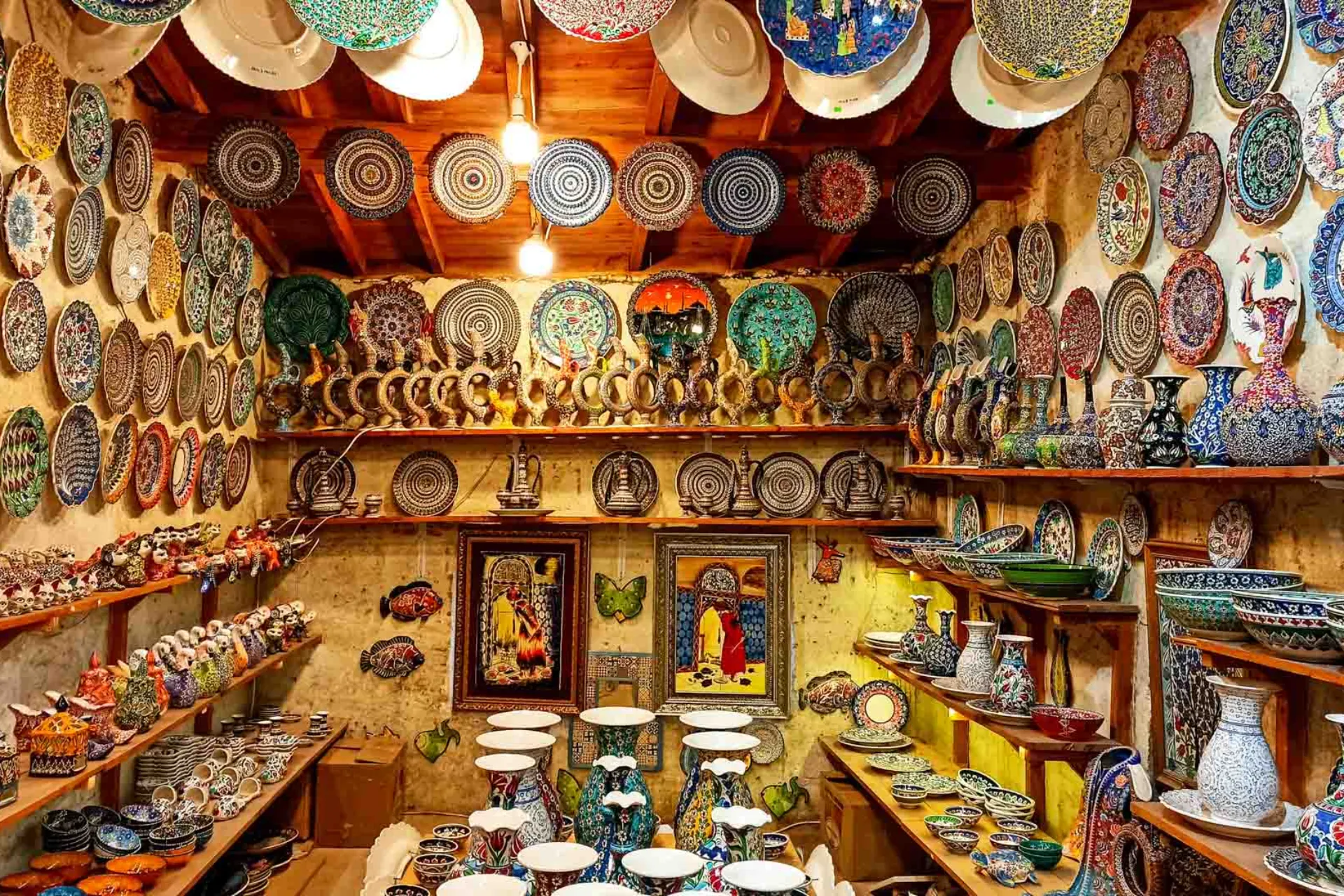 Butikk med fargerike, håndmalte keramikkplater, boller og vaser i en koselig, rustikk atmosfære Butikk med fargerike, håndmalte keramikkplater, boller og vaser i en koselig, rustikk atmosfære