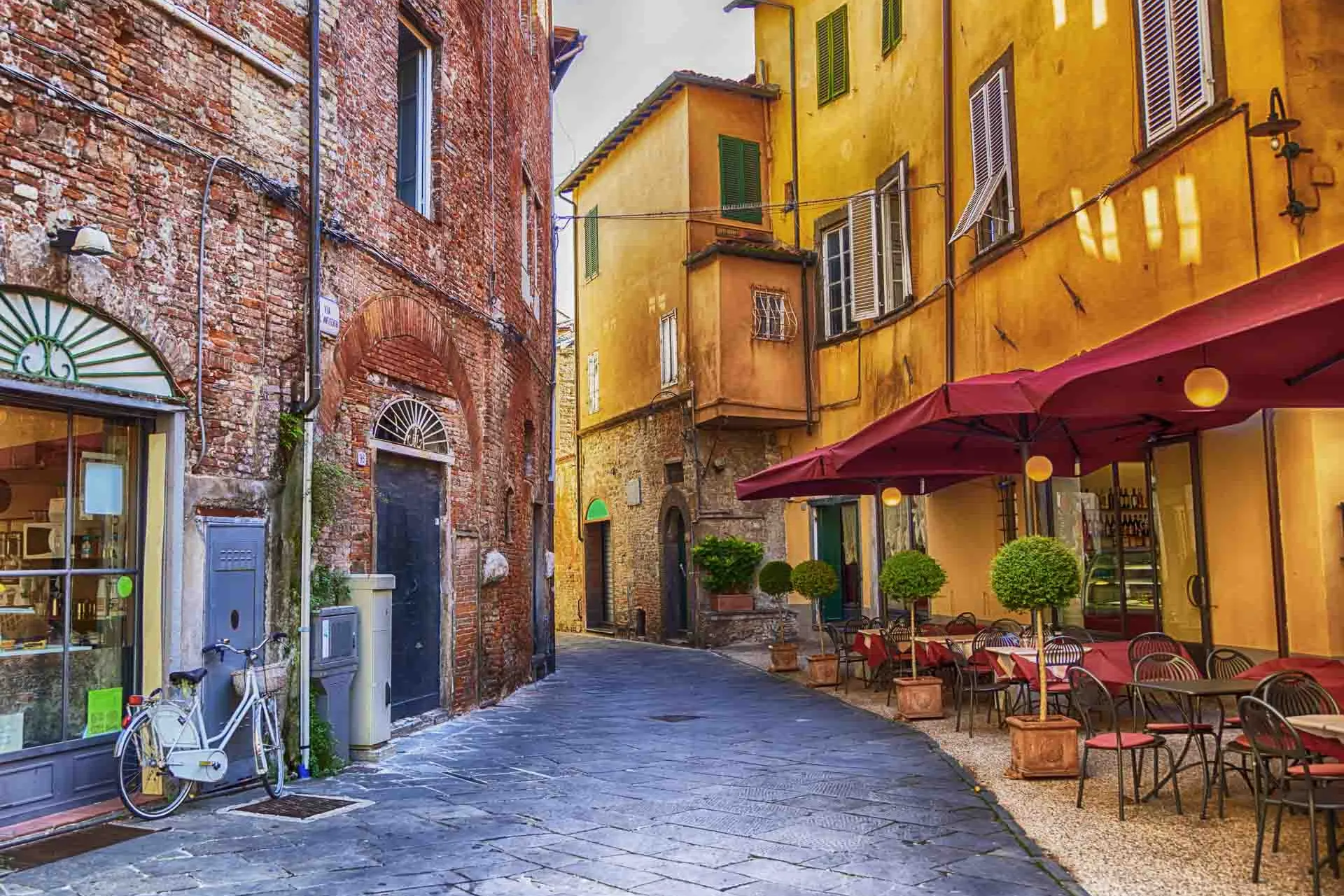 Koselig gate i Lucca med kafé og fargerike hus