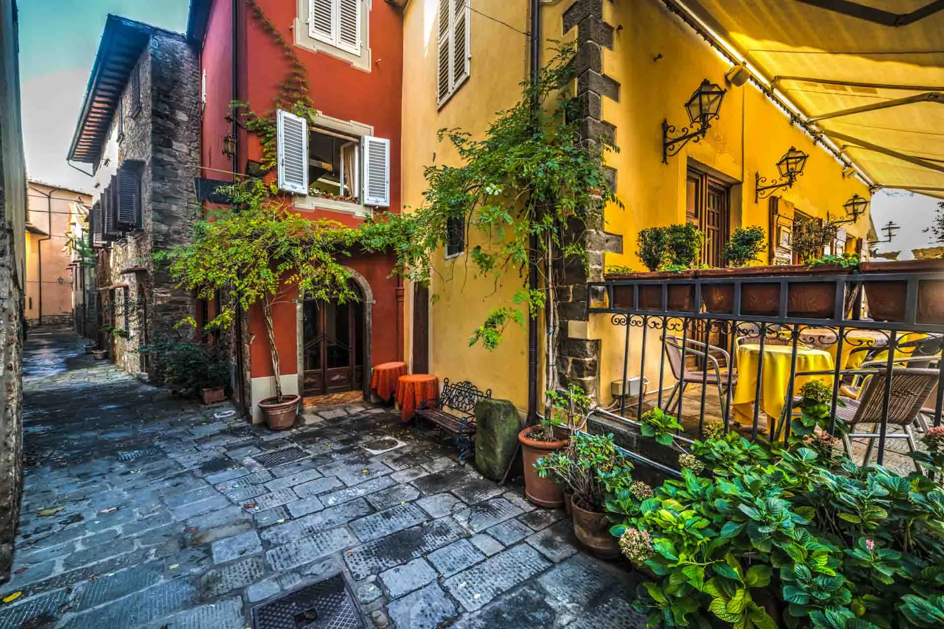 Koselig smug i Montecatini Alto med fargerike hus og planter