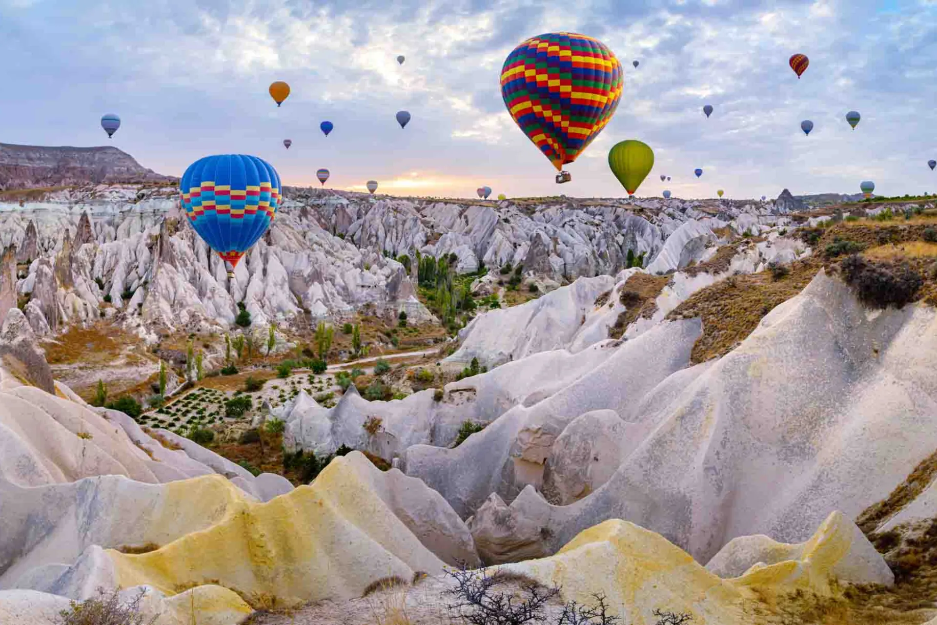 Varmluftballonger svever over de unike fjellformasjonene i Kappadokia Varmluftballonger svever over de unike fjellformasjonene i Kappadokia