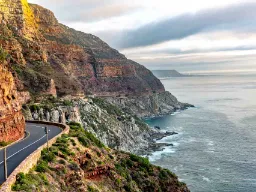 Veien til Chapmans Peak nær Cape Town er hugget direkte inn i de bratte klippene Veien til Chapmans Peak nær Cape Town er hugget direkte inn i de bratte klippene