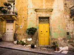 Sjarmerende fasade med gul dør i Vittoriosa – et eksempel på Maltas fargerike bymiljø