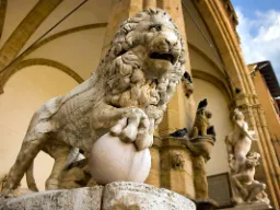 Løveskulptur i marmor omgitt av kunstneriske detaljer