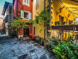 Koselig smug i Montecatini Alto med fargerike hus og planter