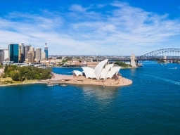 Luftfoto av Sydney med havnebroen, Operaen og byens skyline