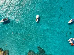 Solskinn og turkisblått vann