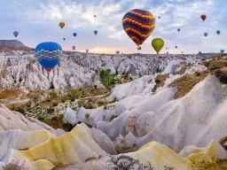 Varmluftballonger svever over de unike fjellformasjonene i Kappadokia Varmluftballonger svever over de unike fjellformasjonene i Kappadokia