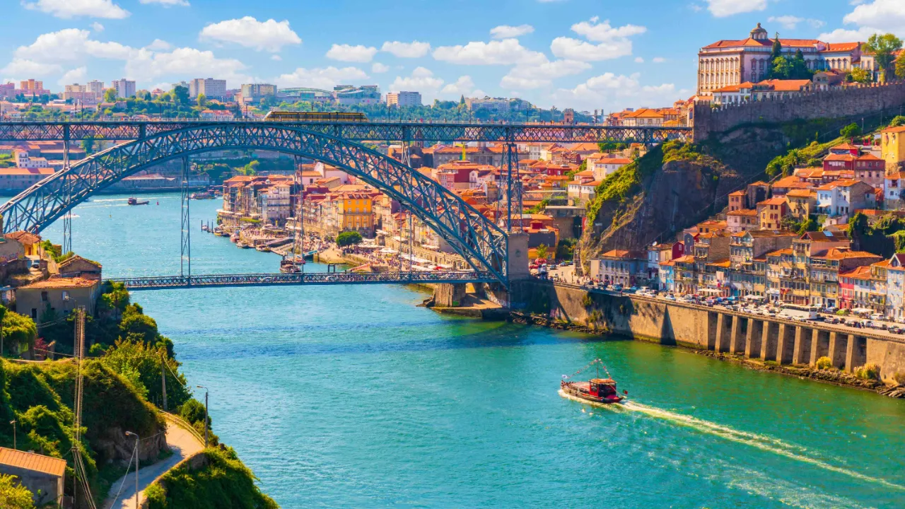 Dom Luís I-broen over Douro-elven med Portos historiske bydeler langs elvebredden Dom Luís I-broen over Douro-elven med Portos historiske bydeler langs elvebredden