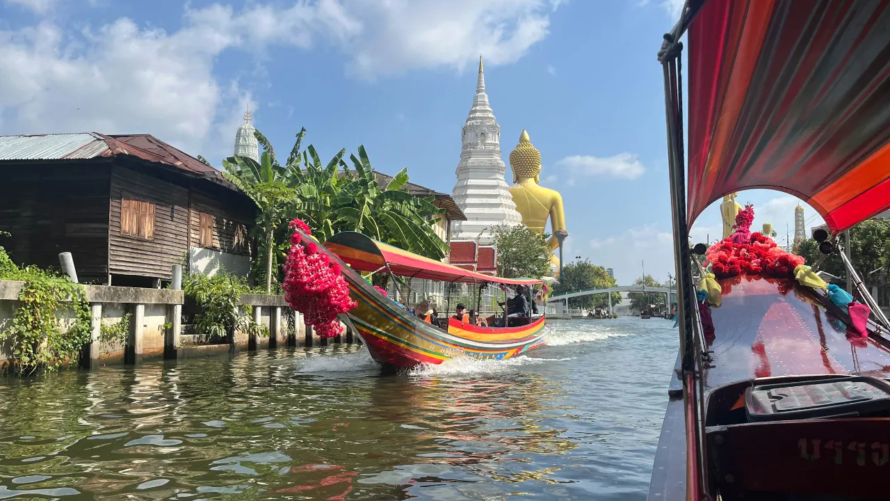 Kanaltur i Bangkok med stor gyllen Buddha-statue og en hvit chedi (stupa) i bakgrunnen Kanaltur i Bangkok med stor gyllen Buddha-statue og en hvit chedi (stupa) i bakgrunnen