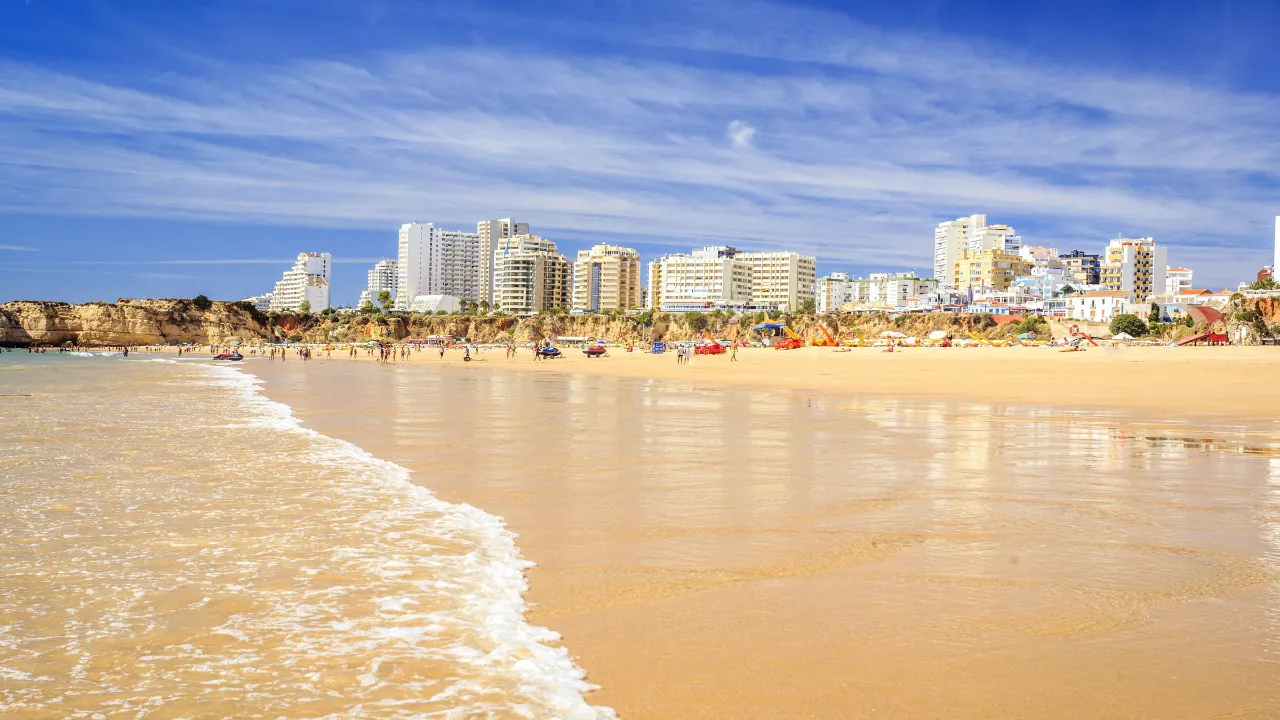 Portimão i bakgrunnen og den innbydende stranden Praia da Rocha i forgrunnen