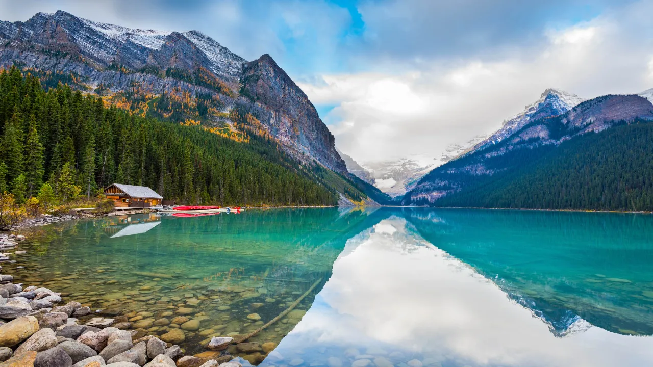 Betagende natur ved Lake Louise med skogkledde fjellskråninger i Banff nasjonalpark, Alberta