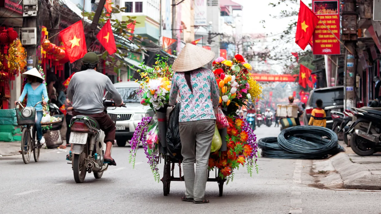 Blomsterselger i en travel gate i Hanoi