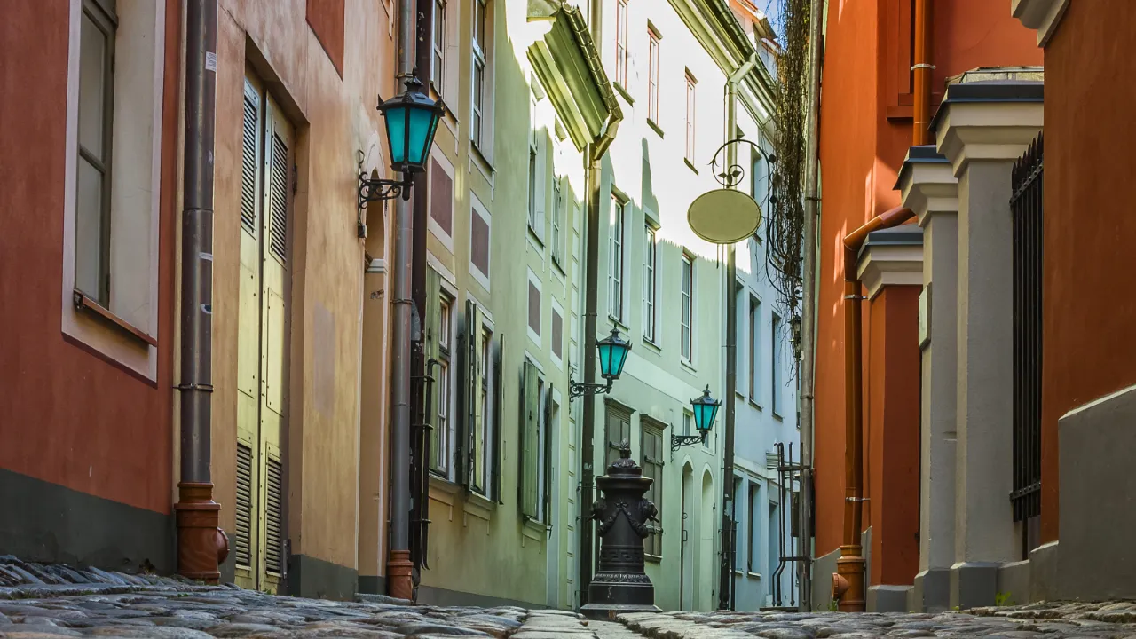 Smal, brosteinsbelagt smug med fargerike fasader i gamlebyen i Riga Smal, brosteinsbelagt smug med fargerike fasader i gamlebyen i Riga