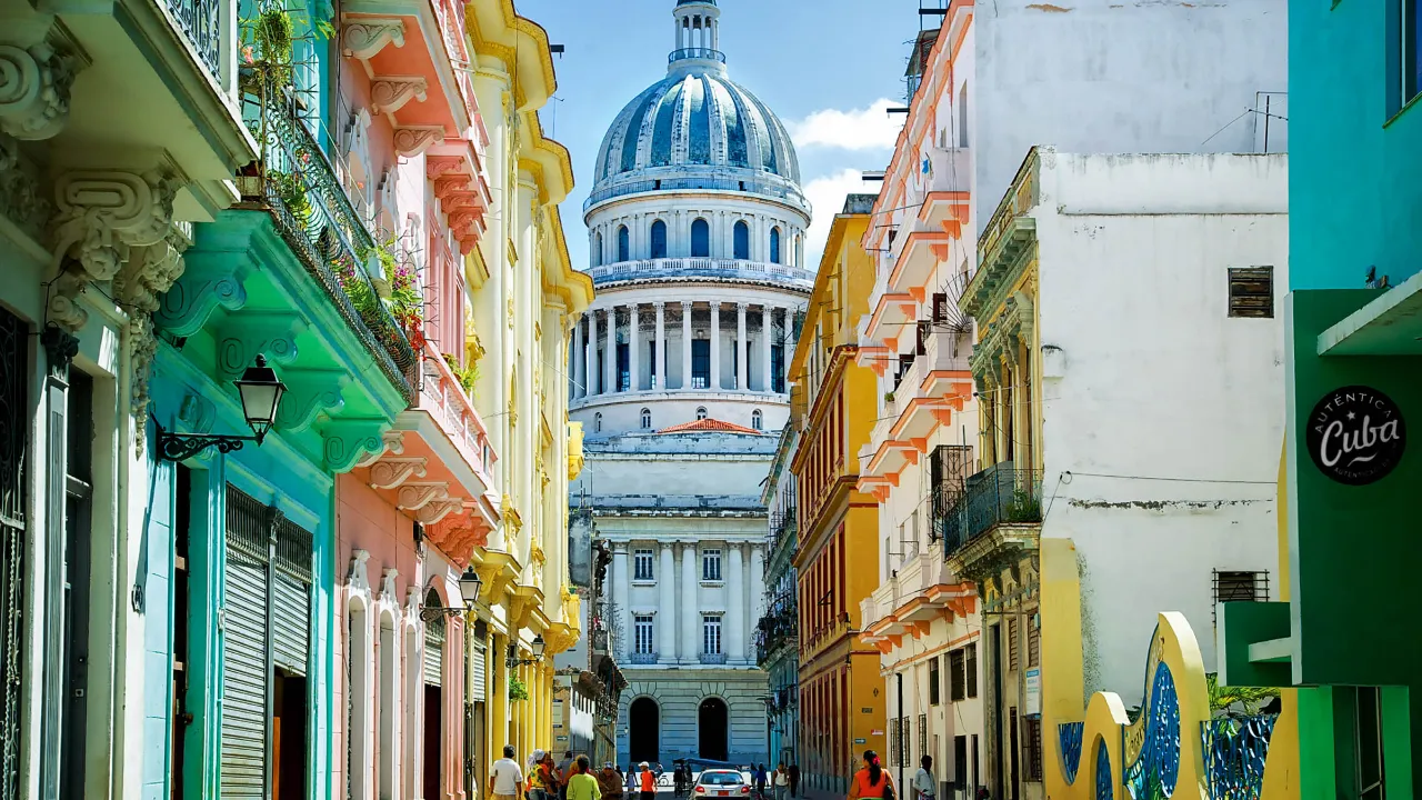 El Capitolio i Havana flankert av koloniale husfasader El Capitolio i Havana flankert av koloniale husfasader