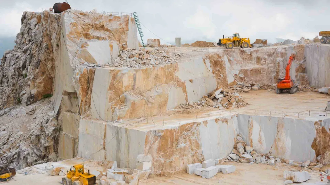 Carrara-marmorbrudd med store steinblokker og arbeidsmaskiner Carrara-marmorbrudd med store steinblokker og arbeidsmaskiner