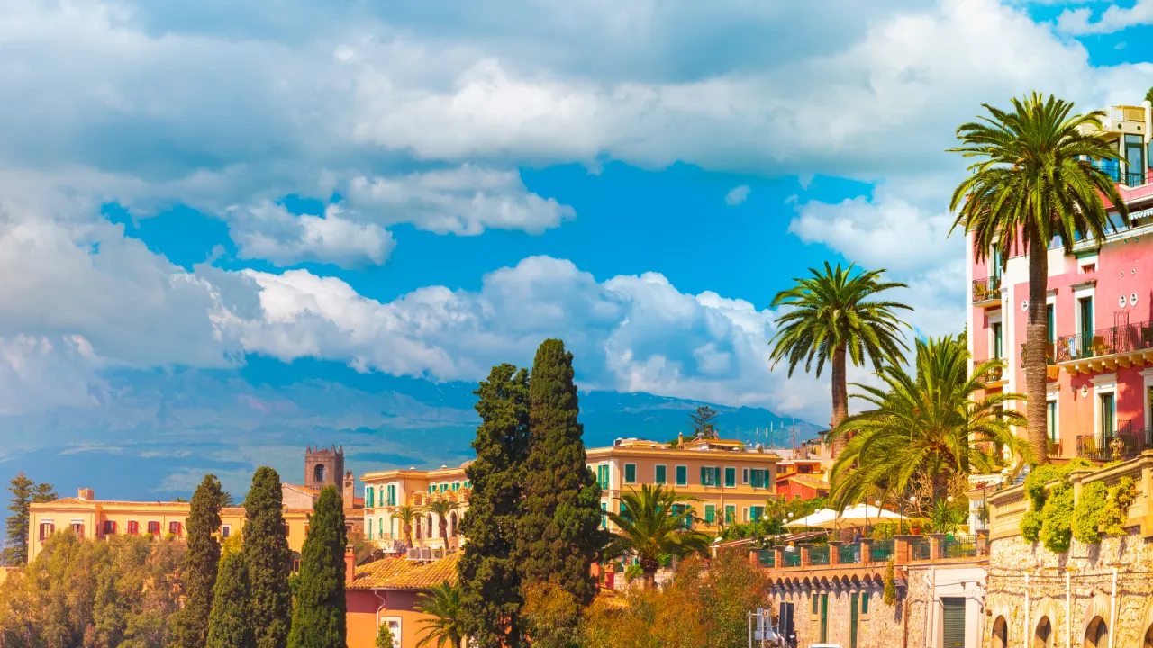Taormina – med vulkanen Etna i bakgrunnen, delvis dekket av skyer.